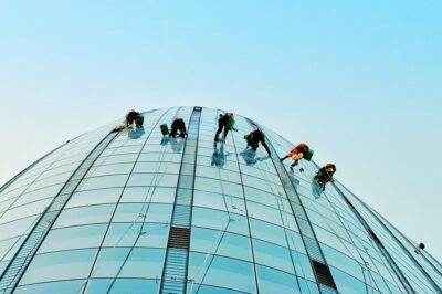 6 Window Washers on Tall Building with Sky 6 Window Washers on Tall Building with Sky